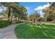 Community park with lush green grass, mature shade trees, and walking path at 1508 Sun Copper Dr, Las Vegas, NV 89117