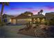 Dusk view of a home with a three-car garage and desert landscaping at 1508 Sun Copper Dr, Las Vegas, NV 89117