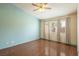 Bedroom featuring light blue accent wall, dark floors, ceiling fan, and large windows at 1837 Alicant Way, Henderson, NV 89014