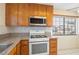 A kitchen featuring light colored countertop with stainless steel microwave and white oven at 1837 Alicant Way, Henderson, NV 89014