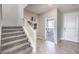 Inviting entryway featuring gray tile flooring, carpeted stairs, and stylish decor leading to a bright dining area at 1921 Lewis Bay Ave # Lot 21, North Las Vegas, NV 89084