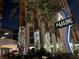 Night view of Allure Las Vegas entrance, featuring palm trees adorned with lights and the building's signage at 200 W Sahara Ave # 2211, Las Vegas, NV 89102
