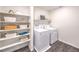 Clean laundry area with washer, dryer, open shelving and wood look flooring at 208 Biscotti Ave # Lot 124, North Las Vegas, NV 89084