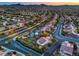 Elevated aerial view displays neighborhood with pristine lawns, lush trees, pools, putting greens, and well-maintained streets at 2248 Carrizo Way, Henderson, NV 89052