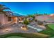Beautiful desert landscaped backyard featuring a putting green, mature palms, and desert plantings at 2248 Carrizo Way, Henderson, NV 89052