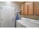 Functional laundry room equipped with washer, dryer, cabinets at 2248 Carrizo Way, Henderson, NV 89052