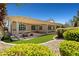 Backyard patio featuring a covered pergola, built-in grill, stone dining table, artificial grass, and lush landscaping at 2373 Black River Falls Dr, Henderson, NV 89044