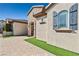 View of home's facade showing arched entryway, shutters, stone details, and manicured lawn at 2373 Black River Falls Dr, Henderson, NV 89044