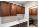 Well-organized laundry room featuring ample cabinet space, a utility sink, and a tiled floor at 2373 Black River Falls Dr, Henderson, NV 89044