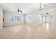 Large open living room with a ceiling fan, fireplace, tile floors, and plantation shutters at 2373 Black River Falls Dr, Henderson, NV 89044