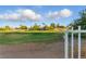 Expansive green space, perfect for outdoor activities, viewed through white metal fence and gate at 2445 Antler Point Dr, Henderson, NV 89074