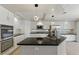 A bright kitchen with white cabinets, stainless steel appliances, and a black countertop island at 2445 Antler Point Dr, Henderson, NV 89074