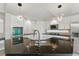 A bright kitchen with white cabinets, stainless steel appliances, and a black countertop island at 2445 Antler Point Dr, Henderson, NV 89074
