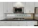 Contemporary kitchen with white cabinets, stainless steel appliances, and a black countertop at 2445 Antler Point Dr, Henderson, NV 89074