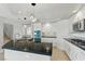 Modern kitchen features white cabinets, black countertops, and stainless steel appliances at 2445 Antler Point Dr, Henderson, NV 89074