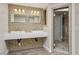 Modern bathroom featuring dual sinks with decorative mirrors, tile backsplash, and glass shower at 3177 Bel Air Dr, Las Vegas, NV 89109