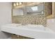 Modern bathroom features dual sinks with decorative mirrors and a tiled backsplash at 3177 Bel Air Dr, Las Vegas, NV 89109