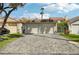 A two car garage with a large brick paver driveway and desert landscaping at 3177 Bel Air Dr, Las Vegas, NV 89109