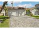 A two car garage featuring a long driveway with brick pavers and desert landscaping at 3177 Bel Air Dr, Las Vegas, NV 89109