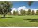 View of the lush green golf course with mature trees and the city skyline in the background on a clear, sunny day at 3177 Bel Air Dr, Las Vegas, NV 89109