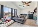 Bright bedroom featuring carpet flooring, a ceiling fan, and large windows at 3332 Beca Faith Dr, North Las Vegas, NV 89032