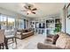 Spacious living room featuring tile flooring, a ceiling fan, and custom built-in shelving at 3332 Beca Faith Dr, North Las Vegas, NV 89032