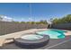 An in-ground pool is accompanied by a jacuzzi surrounded by a block fence at 3332 Beca Faith Dr, North Las Vegas, NV 89032