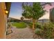 Picturesque backyard with manicured lawn, mature trees, and stunning mountain views at twilight at 35 Via Rizzuto, Henderson, NV 89011