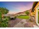 Landscaped backyard featuring a manicured lawn, patio, and breathtaking mountain views at 35 Via Rizzuto, Henderson, NV 89011