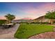 Expansive backyard with lush green lawn, patio dining, and captivating mountain vistas at sunset at 35 Via Rizzuto, Henderson, NV 89011