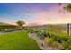Beautifully landscaped backyard featuring lush lawn, scenic views, and serene seating areas at 35 Via Rizzuto, Henderson, NV 89011