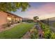 Manicured backyard featuring lush landscaping, an outdoor dining area, and comfortable seating, perfect for enjoying sunset views at 35 Via Rizzuto, Henderson, NV 89011