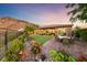 Serene backyard with lush landscaping, patio dining area, and mountain views at 35 Via Rizzuto, Henderson, NV 89011