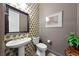 Elegant half bathroom with pedestal sink, designer wallpaper and decorative mirror at 35 Via Rizzuto, Henderson, NV 89011