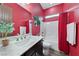 Contemporary red bathroom boasts a marble countertop vanity and a shower with a curtain at 35 Via Rizzuto, Henderson, NV 89011