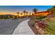 Regatta Heights community entrance with palm trees and stone wall feature at dusk at 35 Via Rizzuto, Henderson, NV 89011