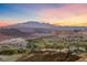 Beautiful community view with golf course, mountains, and vibrant sunset in the background at 35 Via Rizzuto, Henderson, NV 89011