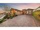 Beautiful home featuring a brick driveway, lush landscaping, and well-manicured greenery at 35 Via Rizzuto, Henderson, NV 89011