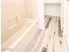A bathtub with tile surround and updated vinyl floors at 3735 Sand Pier St, Las Vegas, NV 89147