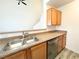 Bright kitchen featuring stainless steel dishwasher and faucet with wood cabinets at 3735 Sand Pier St, Las Vegas, NV 89147