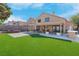 Backyard features artificial grass, a covered patio with dining area, and mature trees at 42 Megan Dr, Henderson, NV 89074