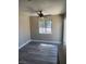 A simple bedroom with gray wood-look floors and a window for natural light at 4536 Payson Ave, Las Vegas, NV 89115