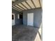 A sheltered carport and a closed room with a white door and grey paneling at 4536 Payson Ave, Las Vegas, NV 89115