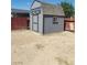 Gray wooden shed in the backyard with a window and a red fence at 4536 Payson Ave, Las Vegas, NV 89115