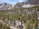 Aerial view of mountain neighborhood surrounded by mature trees and views of snow-capped mountains at 4578 Yellow Pine Ave, Mount Charleston, NV 89124