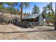 Charming home featuring distinctive architecture, a fenced yard, and mature trees, offering a serene and inviting atmosphere at 4578 Yellow Pine Ave, Mount Charleston, NV 89124