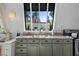 A bright kitchen with green cabinets, granite countertops, and stainless steel appliances at 4578 Yellow Pine Ave, Mount Charleston, NV 89124