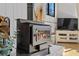 A rustic wood stove with glass door and brick hearth creates a cozy atmosphere at 4578 Yellow Pine Ave, Mount Charleston, NV 89124
