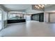Open-concept living room showcasing modern lighting, an adjacent kitchen, and sleek gray walls at 4731 Torrence Dr, Las Vegas, NV 89103