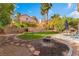 Inviting backyard with grass, patio area, fire pit, and mature desert landscaping at 4817 Friar Ln, Las Vegas, NV 89130